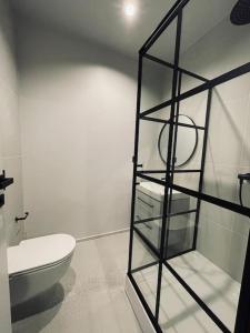 a bathroom with a toilet and a glass shelf at Brand new terraced house. in Mažeikiai