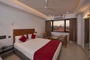 Schlafzimmer mit einem Bett, einem Schreibtisch und einem Fenster in der Unterkunft Venice Iva Residency in Alappuzha