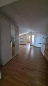 an empty room with white walls and a wooden floor at Casetta al centro in Tuscania