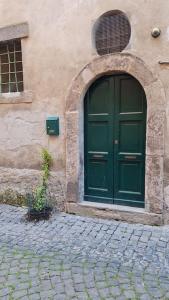 een groene deur aan de zijkant van een gebouw bij Casetta al centro in Tuscania