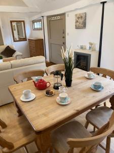 una mesa de madera y sillas en la sala de estar. en The Parlour-Farm Stay-IndoorPool-Play Areas-Parkland-Woodland-Lake-Ponds-min 2 nights, en Lechlade