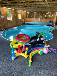 un gato tirado en el suelo junto a una piscina en The Parlour-Farm Stay-IndoorPool-Play Areas-Parkland-Woodland-Lake-Ponds-min 2 nights, en Lechlade