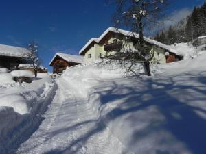 a snow covered path leading to a cabin with a house at Haus Deule in Sankt Gallenkirch