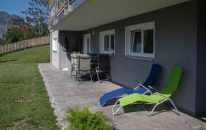 - un ensemble de chaises assises sur une terrasse à côté d'une maison dans l'établissement Ferienwohnung Julia, à Bartholomäberg