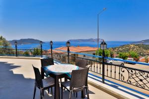 a table and chairs on a balcony with a view of the ocean at Carpediem Apart in Kaş