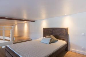 een slaapkamer met een groot bed met een houten hoofdeinde bij Studio By KAZUBUNTU in Saint-Leu