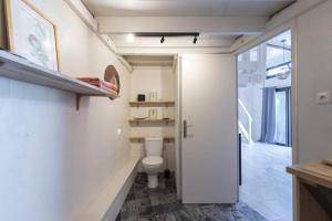 a bathroom with a white toilet in a room at Studio By KAZUBUNTU in Saint-Leu