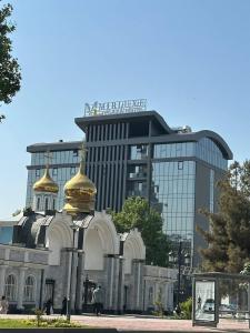 a building with two gold domes in front of a building at Mir Luxe Plaza in Tashkent
