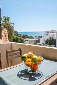 a bowl of fruit sitting on a table on a balcony at #006 Foxy D by Home Holidays in Caliços