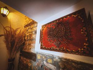 un cuadro colgado en una pared de ladrillo con una lámpara en Bujtina Bega en Berat