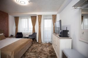 a hotel room with a bed and a flat screen tv at Hotel Del Ponte in Târgovişte