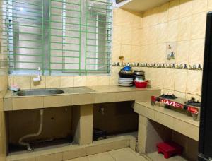 a kitchen counter with a sink and a window at Mohammadia Restaurant & Guest House in Dhaka