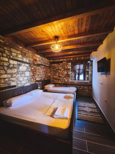 Pokój z 2 łóżkami w ceglanej ścianie w obiekcie Bujtina Bega w mieście Berat