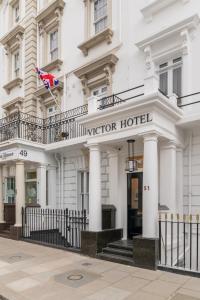 a white hotel with a sign on the front of it at Mornington Victor Hotel London Belgravia in London