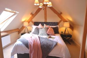 Un dormitorio con una cama con almohadas. en The Blended Barn, en Stratford-upon-Avon