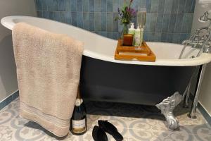 a bathroom with a bath tub with a bottle of champagne at Piglet's Hideaway in Stratford-upon-Avon