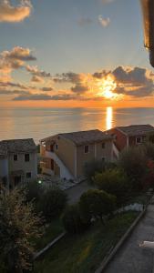 a sunset over the ocean with houses and condos at Costal apartment in Glyfada