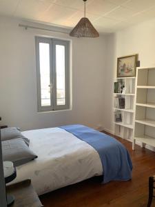 ein Schlafzimmer mit einem großen Bett und einem Fenster in der Unterkunft Coquillage bleu in Six-Fours-les-Plages