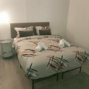 uma cama num quarto com uma cama grande com almofadas em Appartement aux portes de Bordeaux em Pont-de-la-Maye