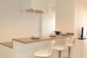 マルグラット・デ・マルにあるRECONNECTAR Malgrat de Mar Garbí Iの椅子3脚とテレビ付きのカウンターがある部屋