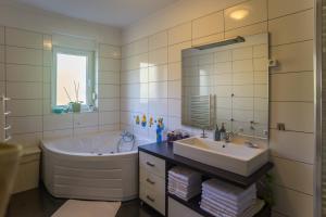 a bathroom with a tub and a sink and a mirror at Apartment Galjanić in Buzdohanj +32 photos