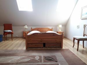 1 dormitorio con 1 cama de madera y 2 sillas en Dom letniskowy Puńsk, en Puńsk