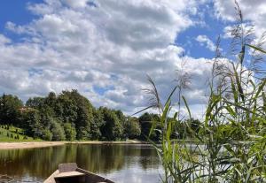 a boat on a river with a cloudy sky at Dom letniskowy Puńsk in Puńsk