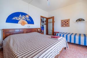 een slaapkamer met een bed met een gestreept dekbed bij Blumele Lovely Sea View Apartment in Deiva Marina +7 foto's