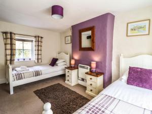 a bedroom with two beds and purple walls at Pen y Bont in Machynlleth