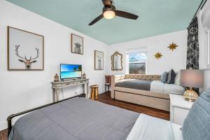 a bedroom with a bed and a couch and a tv at Tropical Waters Hideaway - Pool Tiki & Lounge in Pompano Beach +27 photos