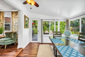 a dining room with a table and chairs and windows at Tropical Waters Hideaway - Pool Tiki & Lounge in Pompano Beach