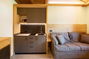 a living room with a couch and a kitchen at Agriturismo Bosco d'oro 2 in Livigno