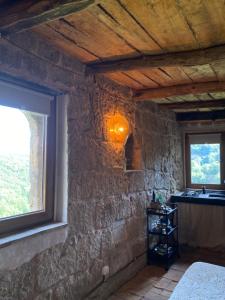 Habitación con pared de piedra, lavabo y ventana. en officina alchemica, en Calcata