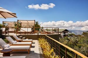 d'une terrasse avec des chaises et un parasol sur le balcon. dans l'établissement Hacienda AltaGracia, Auberge Resorts Collection, à Santa Elena