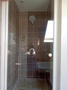 a bathroom with a shower with brown tile at On dirait le Sud 