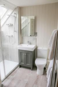 a bathroom with a sink and a toilet and a shower at Cosy Modern Cottage - Wareham in Wareham