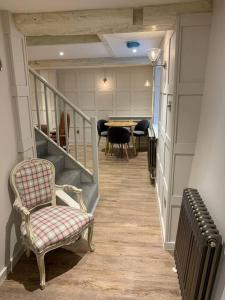 a hallway with a stairway with a chair and a table at Cosy Modern Cottage - Wareham in Wareham
