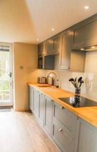 a kitchen with stainless steel cabinets and a sink at Cosy Modern Cottage - Wareham in Wareham