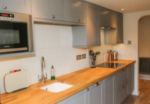 a kitchen with a wooden counter top with a sink at Cosy Modern Cottage - Wareham in Wareham