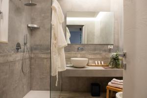 La salle de bains est pourvue d'une douche, d'un lavabo et d'un miroir. dans l'établissement San Nicolicchio - Luxury Guest House, à Tarente