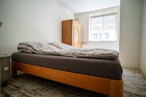 een slaapkamer met een bed in een kamer met een raam bij Appartement Atmospheria in romantische stolp in Warmenhuizen