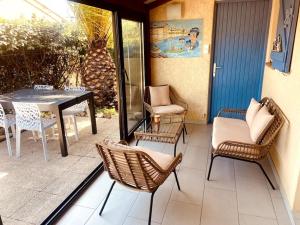 a patio with chairs and a table and a table and chairs at Villa N°7 à 100m de la plage in Saint-Cyprien +4 photos