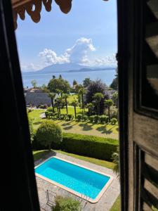 Blick auf den Pool aus dem Fenster in der Unterkunft VSC Apartment - Appartamento in villa storica vista lago e piscina in Lesa