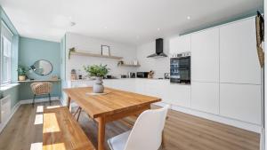 a kitchen with a wooden table and white cabinets at Host & Stay - Lark Lane Hideaway in Liverpool