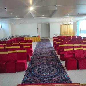 a large room with red chairs and a carpet at Hotel The Golf 1 in Lucknow
