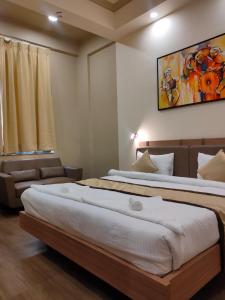 a bedroom with two beds and a couch at Hotel The Golf 1 in Lucknow