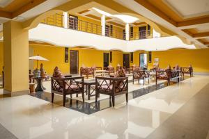 a restaurant with tables and chairs in a building at The Loft Hotel, Siliguri in Siliguri