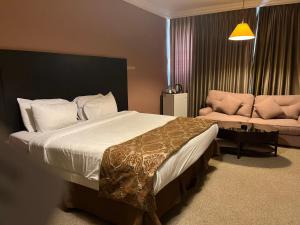 a bedroom with a large bed and a couch at Shepherd Hotel in Amman