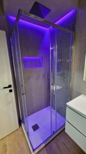 y baño con ducha con luces moradas. en CASA FORTUNATO, en Bolonia