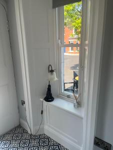 une fenêtre avec une lampe assise sur un rebord de fenêtre dans l'établissement Wellington Cottage, à Wexford